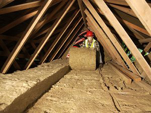 Rolling out insulation in the attic; photo courtesy Sarah Gotheridge